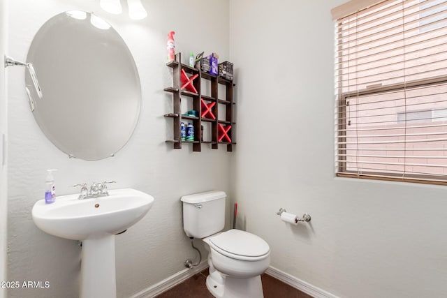 bathroom featuring toilet and baseboards