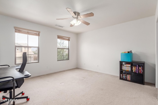 carpeted office with visible vents, baseboards, and a ceiling fan