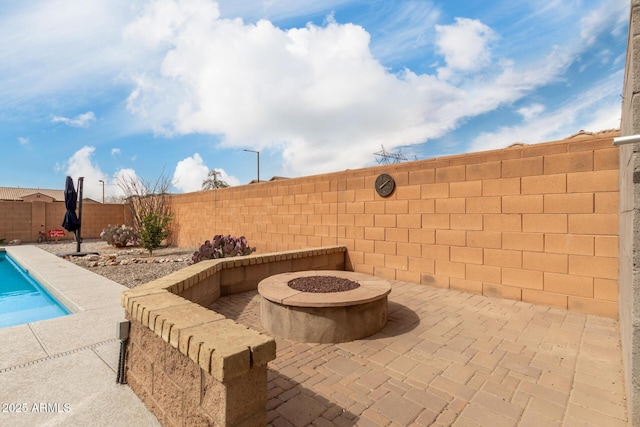 view of patio / terrace with a fenced in pool, a fire pit, and a fenced backyard