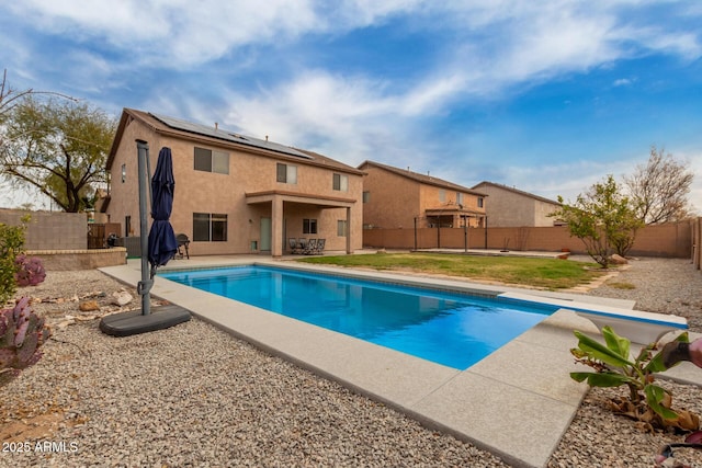 view of swimming pool with a diving board, a fenced in pool, a fenced backyard, and a patio area