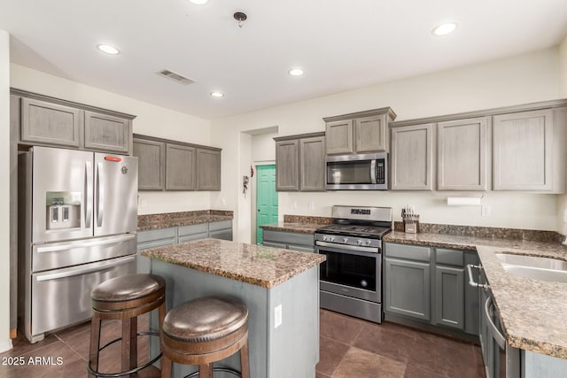 kitchen featuring visible vents, dark tile patterned flooring, a kitchen island, recessed lighting, and appliances with stainless steel finishes