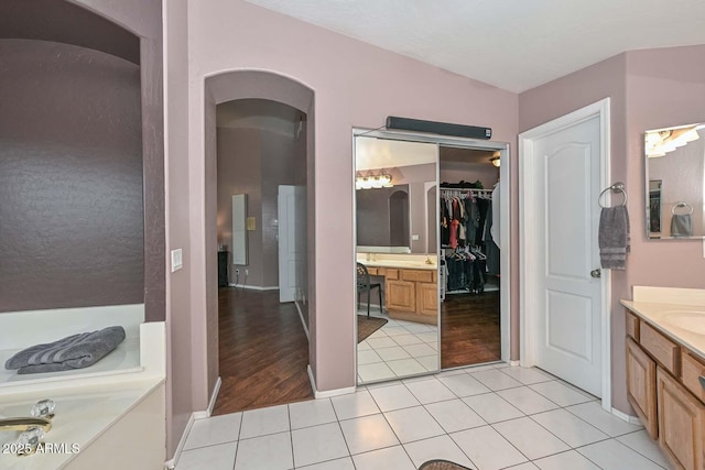 bathroom with tile patterned flooring, vanity, and a bathtub