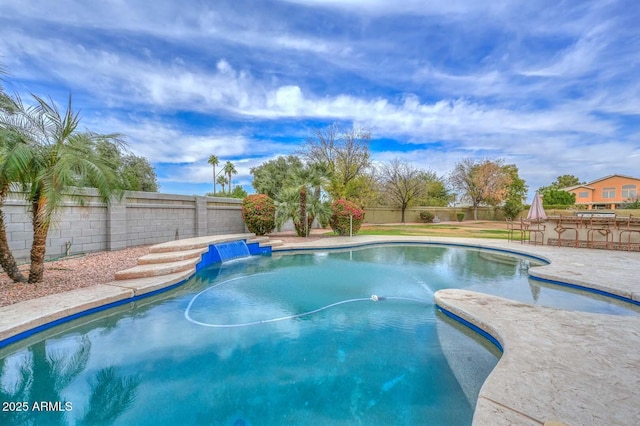 view of swimming pool featuring pool water feature and an outdoor bar