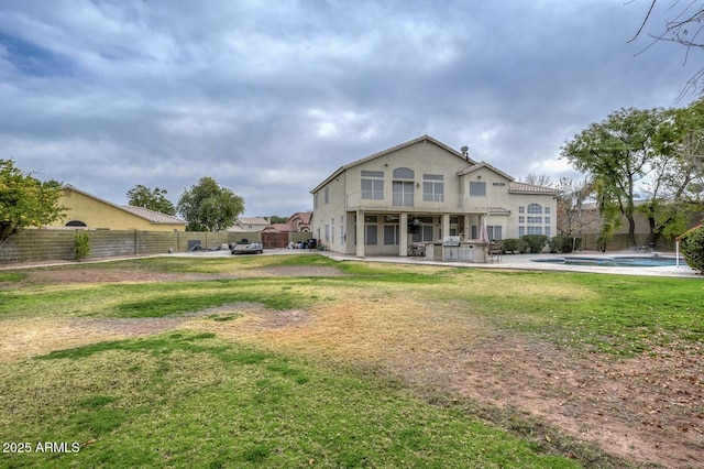 back of house with a lawn, a fenced in pool, and a patio