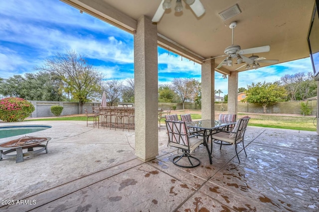 view of patio / terrace with ceiling fan and an outdoor bar