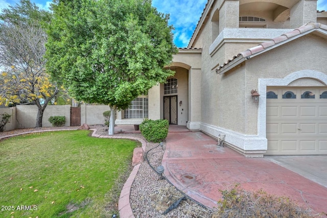 view of exterior entry featuring a lawn and a garage