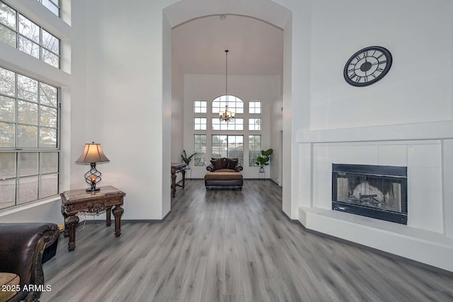 hallway featuring a towering ceiling, a chandelier, and light wood-type flooring