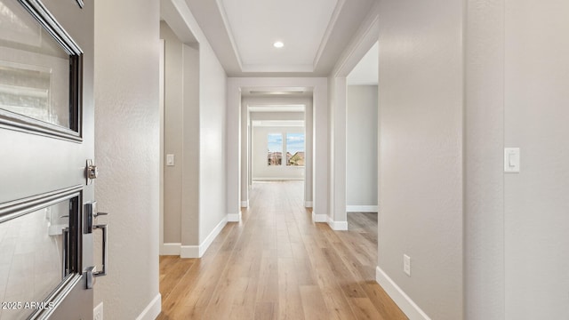 hallway featuring light wood-type flooring, baseboards, and recessed lighting