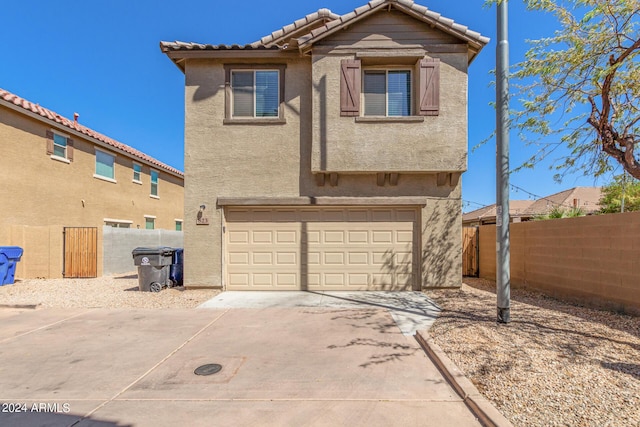 823 E Agua Fria Ln, Avondale, AZ 85323 - back of house featuring an attached garage, stucco siding, concrete driveway, and fence