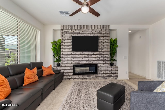 living room featuring ceiling fan and a brick fireplace