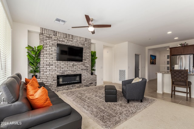 living room featuring light tile patterned flooring, a brick fireplace, and ceiling fan