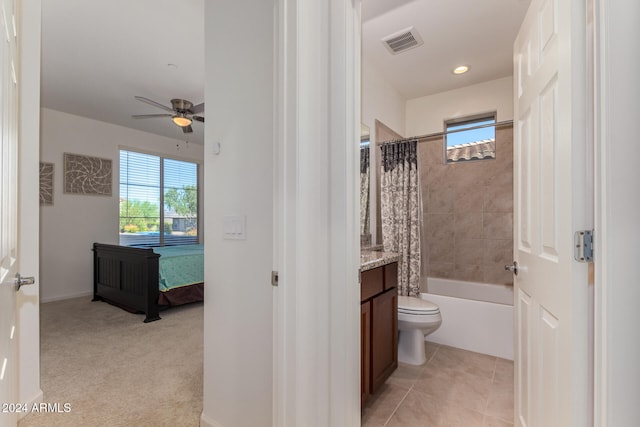 full bathroom featuring toilet, ceiling fan, tile patterned floors, vanity, and shower / tub combo with curtain