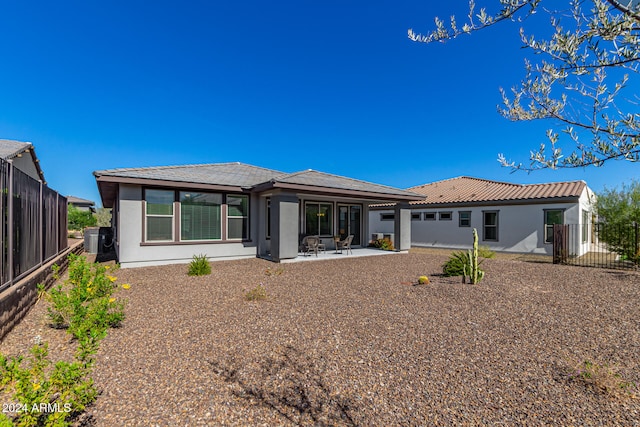 rear view of house with a patio and central AC unit