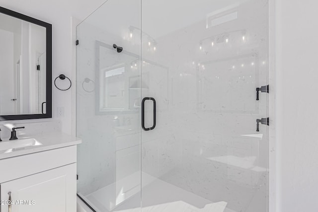 full bathroom with a marble finish shower and vanity