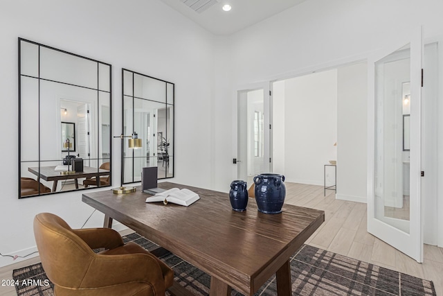 office space with a high ceiling, french doors, light wood-type flooring, and baseboards