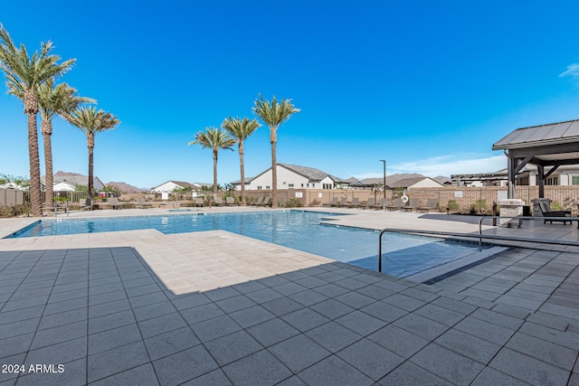 pool with a patio area and fence