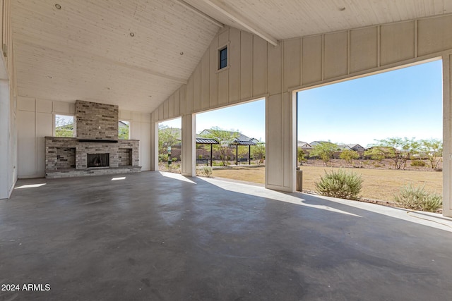 unfurnished living room featuring a large fireplace, beamed ceiling, concrete floors, and high vaulted ceiling