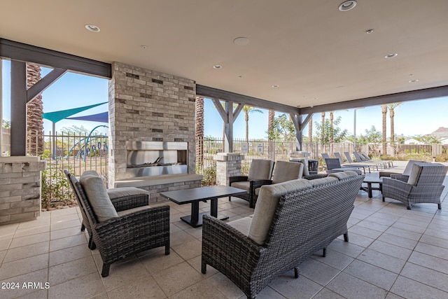 view of patio featuring fence and an outdoor living space with a fireplace