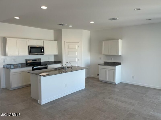 kitchen with sink, white cabinets, appliances with stainless steel finishes, and a kitchen island with sink