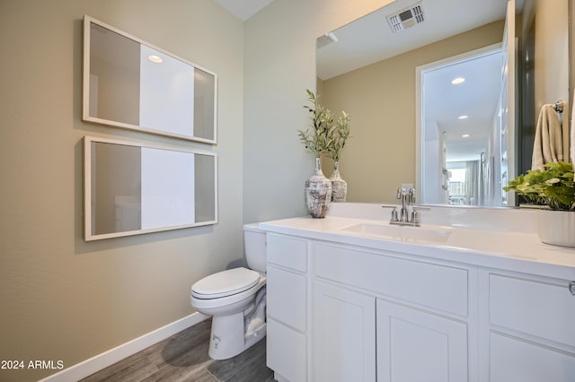 bathroom featuring vanity, hardwood / wood-style floors, and toilet