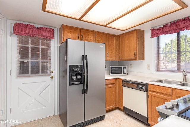 kitchen with sink, light tile patterned floors, and stainless steel appliances