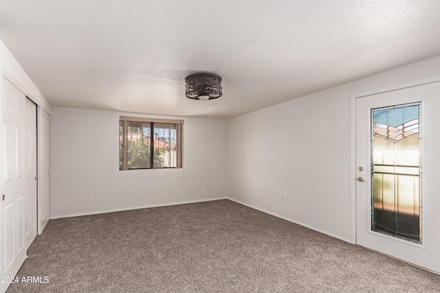 unfurnished bedroom featuring carpet flooring and a textured ceiling