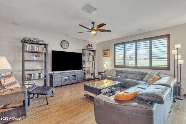 living area with light wood-type flooring, visible vents, and ceiling fan