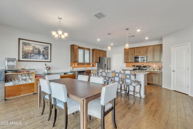 dining room featuring light wood finished floors, visible vents, a notable chandelier, and recessed lighting