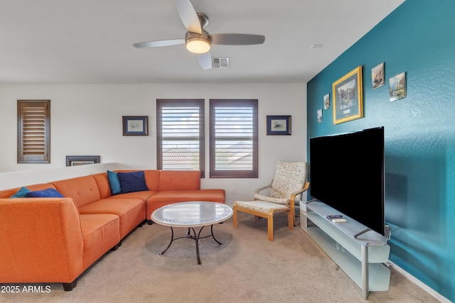 living area with carpet, visible vents, and a ceiling fan