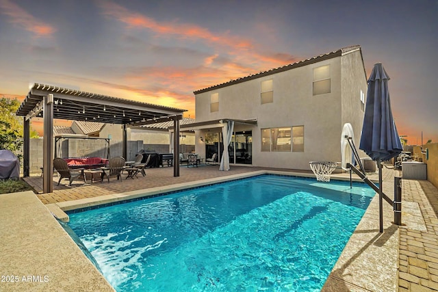 back of house at dusk featuring a fenced in pool, stucco siding, a patio area, a pergola, and an outdoor living space