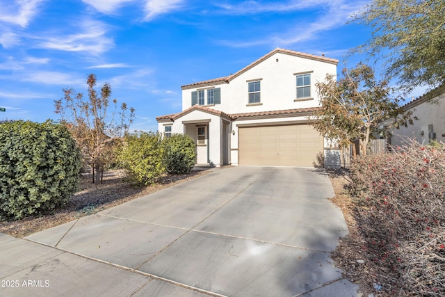 mediterranean / spanish home featuring a tiled roof, an attached garage, driveway, and stucco siding