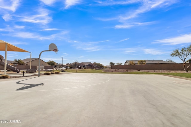 view of basketball court featuring community basketball court, fence, and a residential view