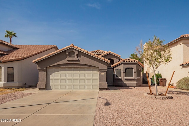 mediterranean / spanish-style home featuring driveway, an attached garage, a tiled roof, and stucco siding