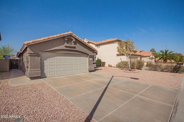 view of front of home featuring a garage, concrete driveway, a tile roof, and stucco siding