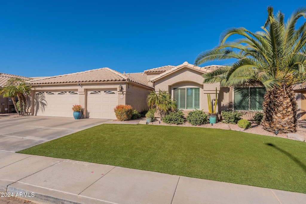 mediterranean / spanish-style house with a front yard and a garage