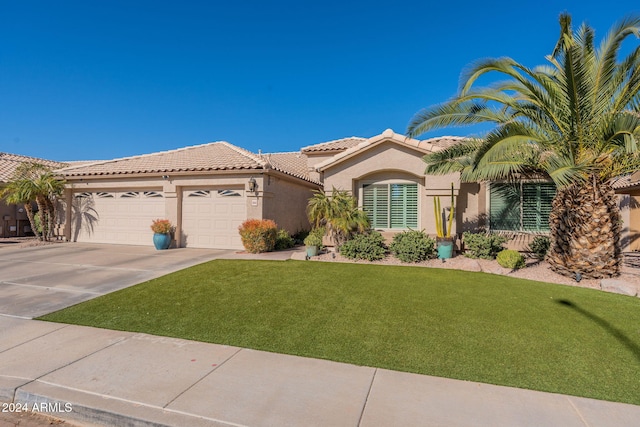 mediterranean / spanish-style house with a front yard and a garage