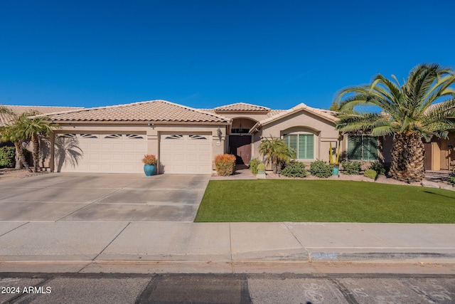 mediterranean / spanish house featuring a front lawn and a garage