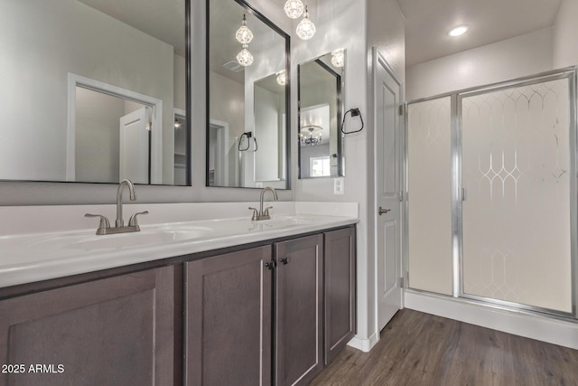 bathroom with hardwood / wood-style flooring, an enclosed shower, and vanity