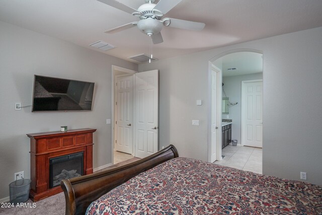 bedroom with ceiling fan, ensuite bathroom, and light tile patterned floors