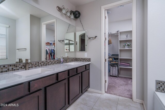 bathroom featuring tile patterned floors, a bathtub, vanity, and tasteful backsplash