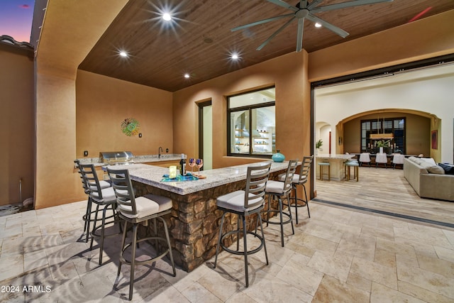 view of patio / terrace featuring ceiling fan and a bar