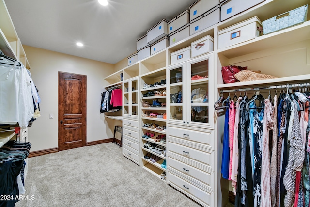 spacious closet featuring light colored carpet