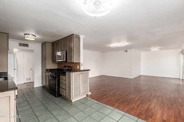 6767 N 7th St Unit 230, Phoenix, AZ 85014 - kitchen featuring gas range, stainless steel microwave, dark wood-style floors, open floor plan, and freestanding refrigerator