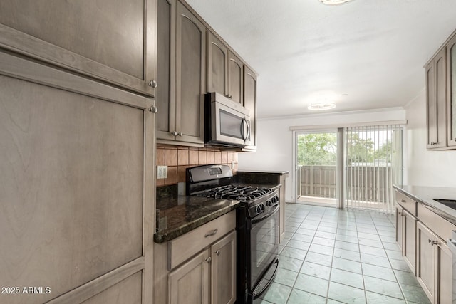 6767 N 7th St Unit 230, Phoenix, AZ 85014 - kitchen featuring stainless steel microwave, black gas stove, backsplash, light tile patterned floors, and dark stone counters