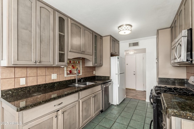 6767 N 7th St Unit 230, Phoenix, AZ 85014 - kitchen featuring stainless steel appliances, a sink, backsplash, glass insert cabinets, and tile patterned floors