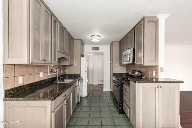 6767 N 7th St Unit 230, Phoenix, AZ 85014 - kitchen with gas range, stainless steel microwave, a sink, decorative backsplash, and dark stone counters