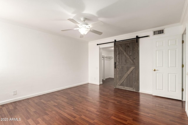 6767 N 7th St Unit 230, Phoenix, AZ 85014 - unfurnished bedroom featuring a barn door, ornamental molding, wood finished floors, baseboards, and a spacious closet
