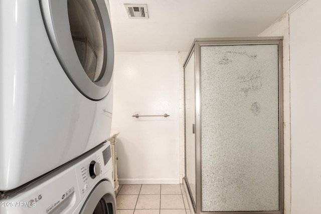 6767 N 7th St Unit 230, Phoenix, AZ 85014 - washroom with stacked washer / drying machine, light tile patterned floors, and baseboards