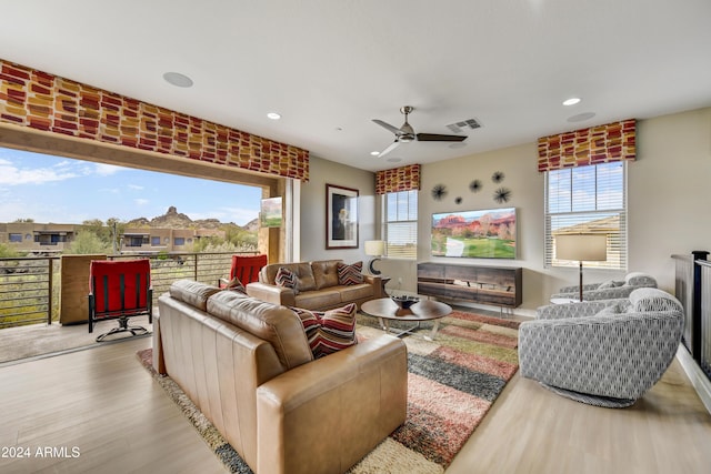 living room with ceiling fan, light hardwood / wood-style flooring, and a wealth of natural light