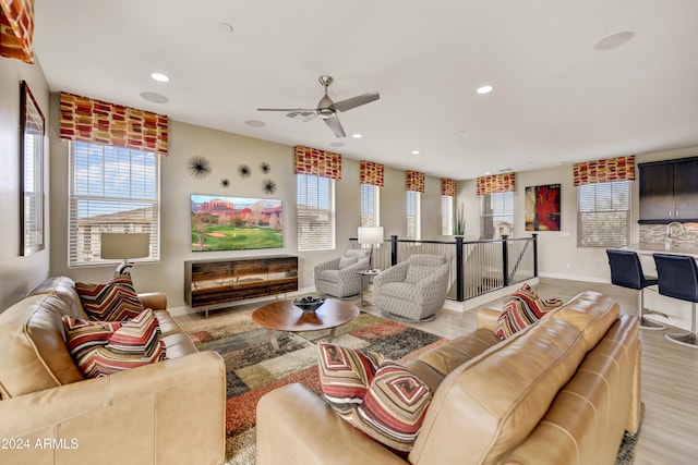 living room with light hardwood / wood-style floors and ceiling fan